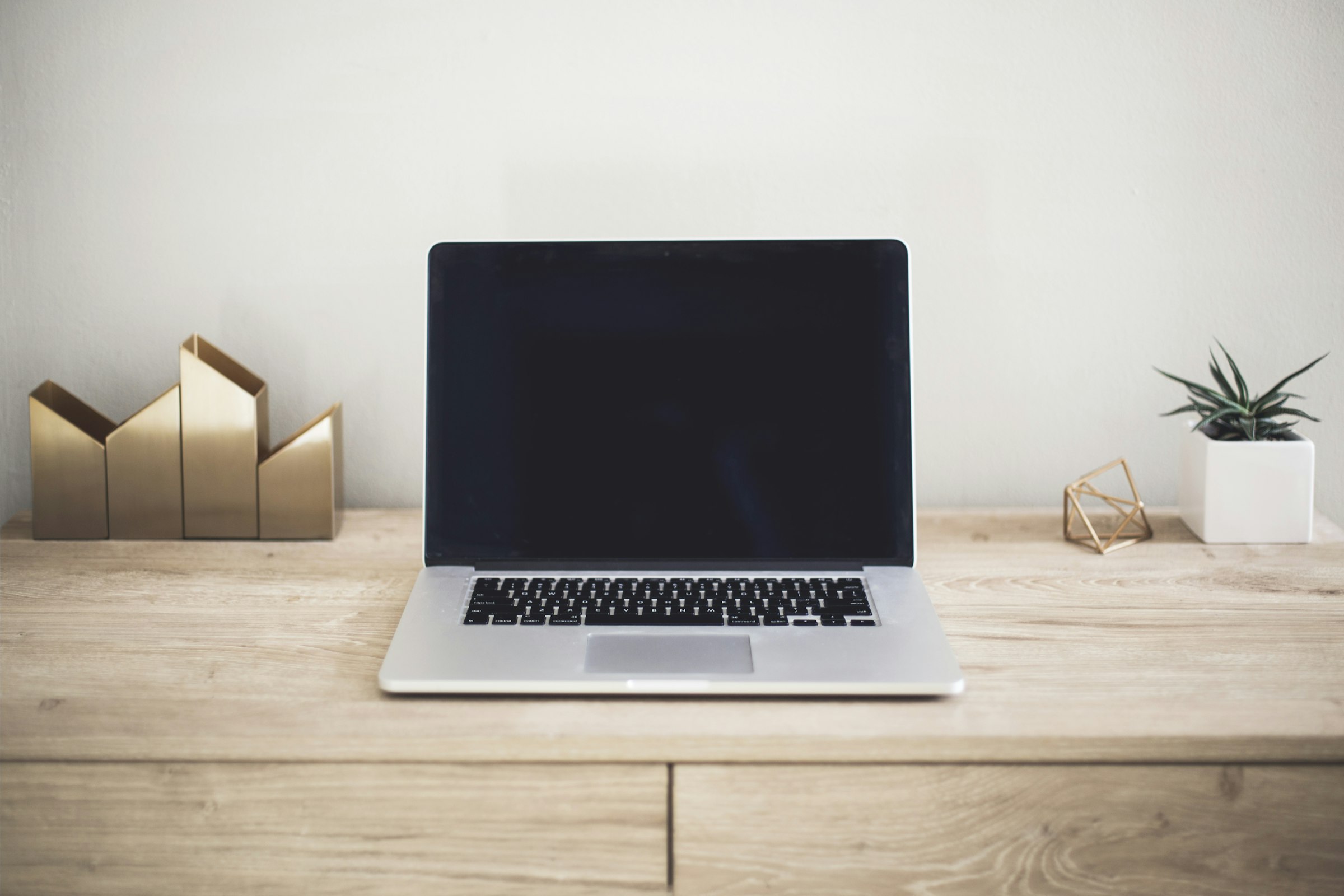 A laptop on a bright, minimal wood desk